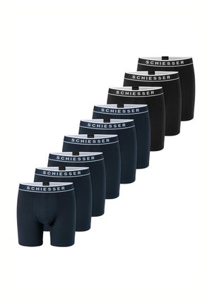 Neuf paires de boxers pour hommes noirs et bleu foncé avec ceintures blanches de la marque "Schiesser" disposées en ligne diagonale.