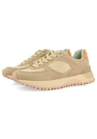 Baskets de sport beiges avec une tige texturée, des accents en maille et une semelle en caoutchouc rose. Les caractéristiques incluent des lacets et une doublure intérieure vert clair.