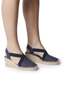 Námořnické plátěné espadrilky na klínu s kříženými elastickými pásky, pletenými jutovými podrážkami a uzavřeným špičkou. Texturovaná tkanina s bočními výřezy.