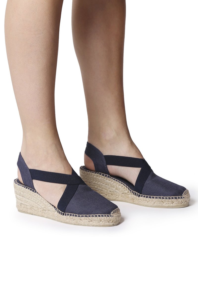 Námořnické plátěné espadrilky na klínu s kříženými elastickými pásky, pletenými jutovými podrážkami a uzavřeným špičkou. Texturovaná tkanina s bočními výřezy.