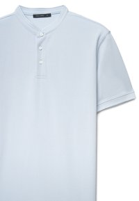 Polo a maniche corte azzurro chiaro realizzata in cotone strutturato, con collo henley a tre bottoni e design dritto.