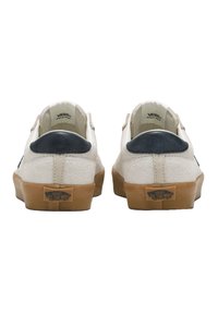 Vans Sneakers mit einem Obermaterial aus beigem Wildleder, navyfarbenen Lederelementen an der Ferse und einer Sohle aus Naturkautschuk. Sichtbares Markenlogo auf der Ferse.