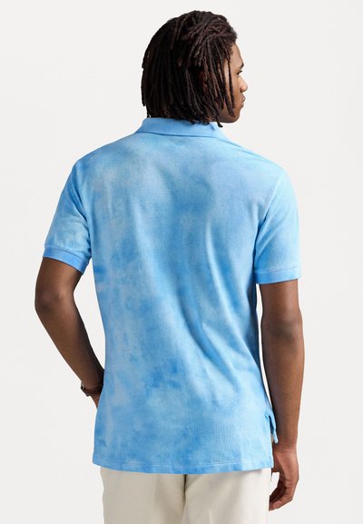 Pánská polokošile s krátkým rukávem v jemném modrém tie-dye vzoru, s texturovaným povrchem, klasickým límečkem a bočními rozparky pro větší pohodlí.