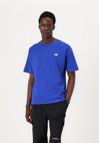 Blauw katoenen T-shirt met een ronde hals en korte mouwen, met een klein wit logo op de linkerborst. Gladde textuur, ontspannen pasvorm.