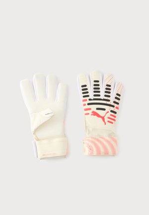 Par de guantes de portero blancos y beige con detalles en negro y rojo, uno con la palma hacia arriba y otro con el dorso hacia arriba, sobre un fondo liso.