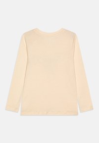 Long-sleeve t-shirt in light beige cotton, featuring a round neckline and stitched hem, with a simple, smooth texture.