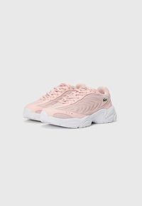 Sapatilhas desportivas rosa claro com painéis de malha e design texturizado, apresentando uma sola de borracha branca e um pequeno logótipo verde de lado.