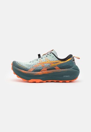 Trailrun schoenen in lichtgroen en donkerteal, met een oranje buitenzool. Beschikt over een gestructureerde bovenkant met dynamische ontwerp lijnen en een trekband.