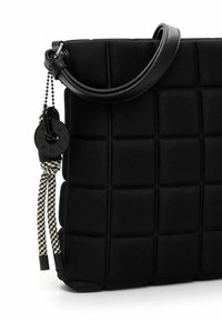 Borsa imbottita nera realizzata in materiale morbido con un manico curvo. Presenta una tracolla decorativa con texture e un accento in hardware circolare.