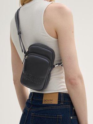 Schwarze strukturierte Kunstleder-Crossbody-Tasche mit zwei mit Reißverschluss versehenen Fächern, verstellbarem Tragegurt und graviertem Markenlogo.