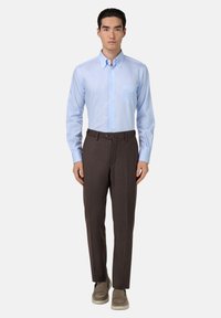 Jasnoniebieska koszula w paski z długimi rękawami, połączona z brązowymi spodniami wizytowymi. Spodnie charakteryzują się gładką teksturą i dopasowanym krojem.