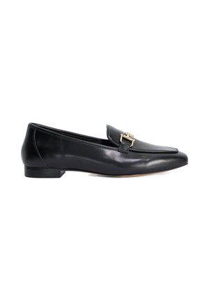 Mocasín plano de cuero negro con tacón bajo y detalle de hebilla dorada en la parte delantera, mostrado de lado sobre un fondo blanco.
