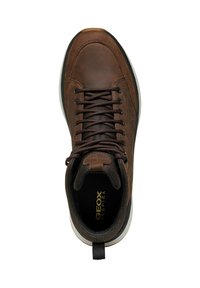 Zapatilla de cuero marrón con punta redondeada, frente con cordones y collar acolchado. Presenta un acento de tejido texturizado y suela blanca en contraste.