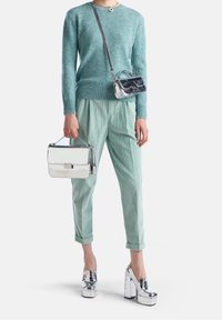 Maglione a maglia turchese chiaro, pantaloni in corduroy verde menta, scarpe con plateau argentate e borsa a tracolla argentata/blu e borsa a mano.