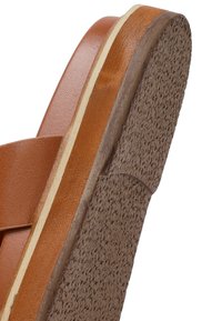 Sandalo in pelle marrone con suola in gomma testurizzata, caratterizzato da un plantare di colore legno naturale e un design semplice e minimalista.