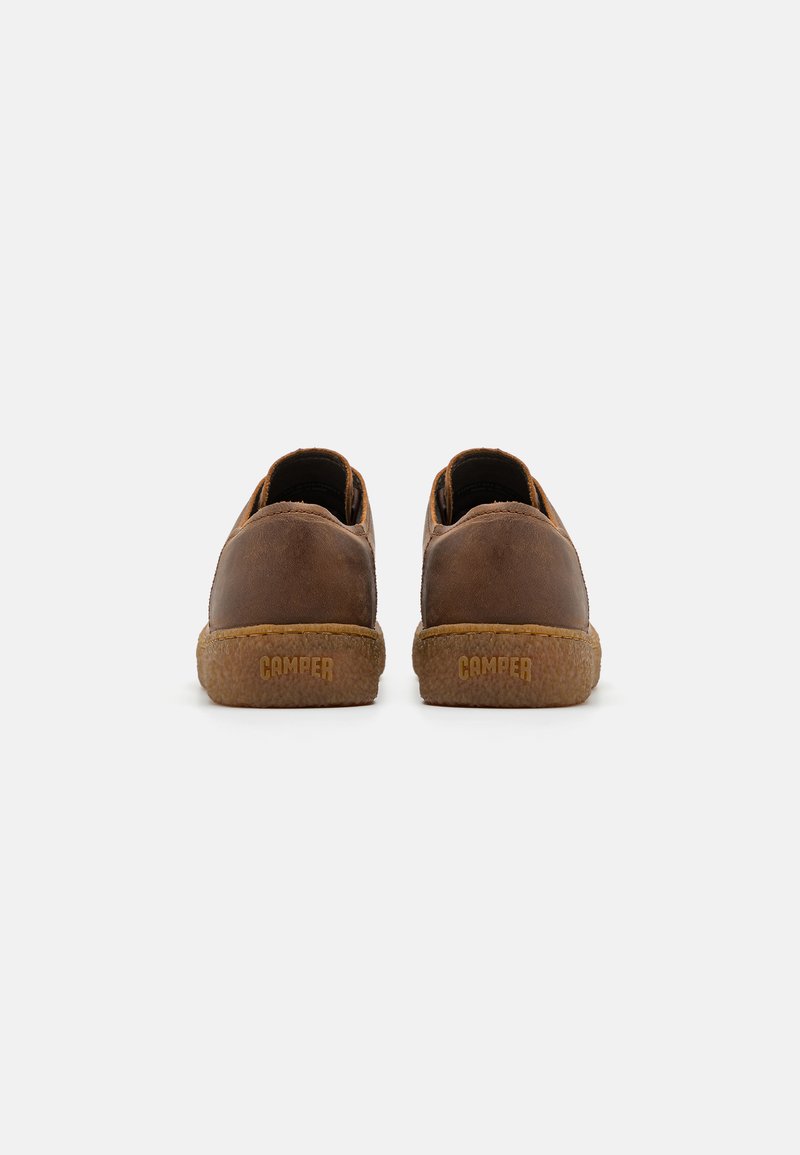 Brown leather slip-on shoes with tan rubber sole. Features a textured finish and stamped "CAMPER" logo on the back.