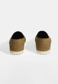 Bruine geperforeerde textile instappers met een geweven beige zool, met een ronde neus en een lage uitsnijding.