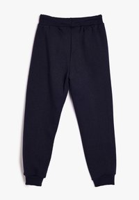 Donkerblauwe sweatpants gemaakt van een zachte stof met een elastische tailleband en cuffs aan de onderkant, met een glad, lichtjes gestructureerd oppervlak.