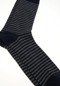 Calze a righe blu navy e grigie realizzate in tessuto morbido; presentano una punta e un polsino blu navy solidi, con strisce alternate di larghezze variabili.