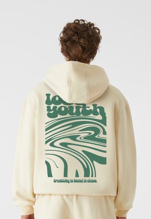Cream hoodie featuring a green abstract design and text on the back, with a drawstring hood and soft, textured fabric.