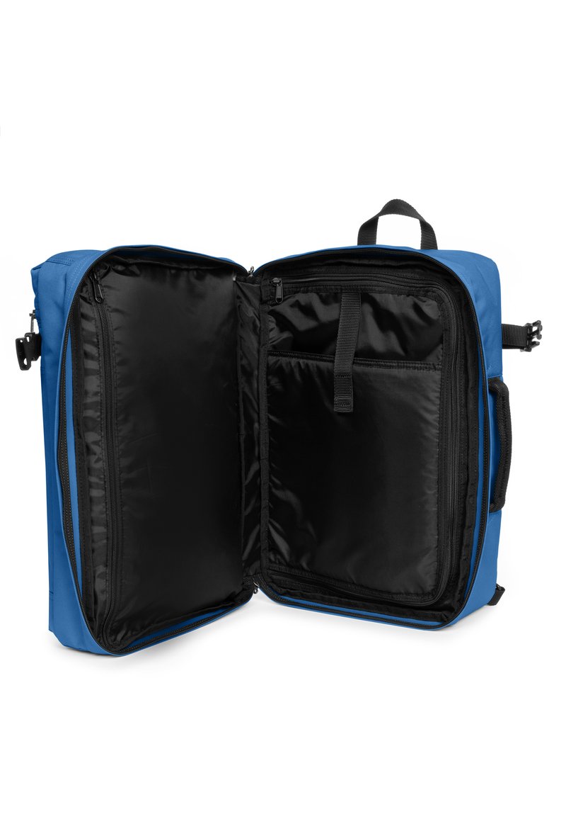Mochila de tela azul con un interior negro, que cuenta con dos compartimentos, bolsillos con cremallera y una asa en la parte superior para llevar.