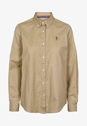 Camisa beige de manga larga con botones, cuello abotonado y pequeño logo bordado en el pecho izquierdo.
