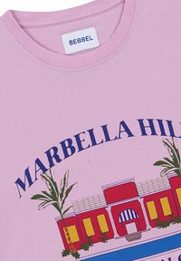 Camiseta de algodón rosa con cuello redondo que presenta una impresión gráfica de un edificio con palmeras y "MARBELLA HILLS" en azul oscuro.