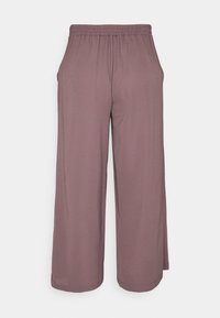 Vaaleanliilat leveälahkeiset housut, jotka on valmistettu pehmeästä kankaasta. Materiaali sisältää joustavan vyötärönauhan ja sivutaskut. Sujuva pinta ja rento istuvuus.