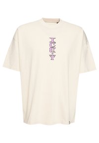 Krémové oversized tričko vyrobené z bavlny. Obsahuje vertikální fialový grafický design se stylizovanými písmeny umístěnými na střed.