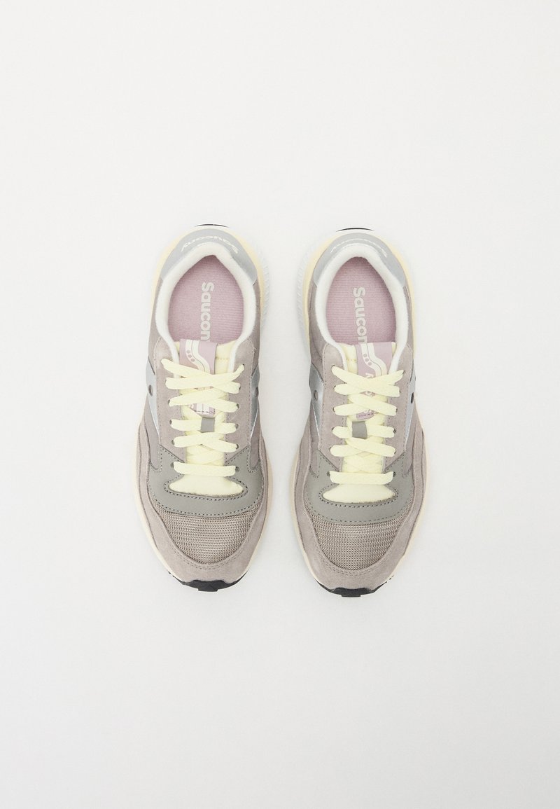 Sneaker beige con dettagli grigi, realizzate in mesh e suede, punta tonda, lacci gialli e un logo discreto sulla soletta e sul lato.