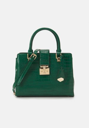 Sac à main vert foncé à texture crocodile avec doubles poignées, bandoulière réglable, fermeture à loquet dorée à l'avant et petite étiquette hexagonale.