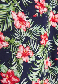 Tecido floral com grandes flores de hibisco vermelhas sobre um fundo azul-marinho escuro, complementado por folhas verdes, com uma textura suave e entrelaçada.