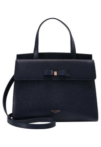 Granatowa torebka wykonana z teksturowanej skóry, charakteryzująca się strukturalnym designem, górnymi uchwytami, odczepianym paskiem oraz akcentem w postaci kokardy na klapie.