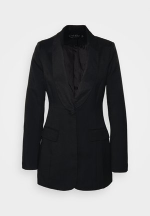 Blazer negro hecho de tela texturizada, con solapa de satén, dos bolsillos frontales y cierre de un botón. El interior está forrado con un material oscuro.