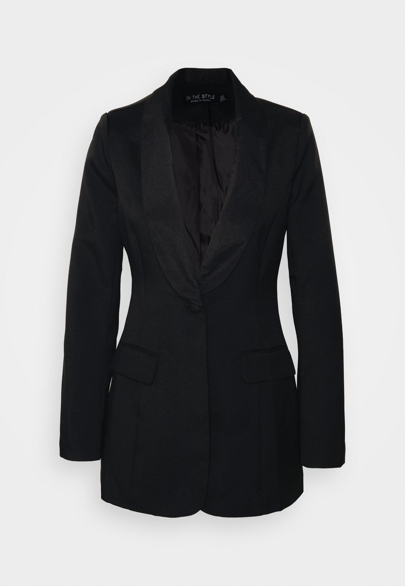 Zwarte blazer van gestructureerde stof, met een satijnen revers, twee voortassen en een enkele knoopsluiting. Binnenkant is gevoerd met donkere stof.