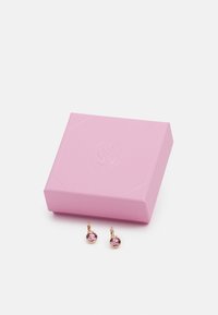 Rose gold earrings with pink gemstones, shown beside a textured pink gift box with a logo embossed on the top.