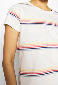 Kortærmet, hvid T-shirt med horisontale striber i pink, gul, blå og marineblå. Blødt bomuldsstof med klassisk rund halsudskæring.