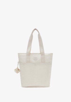 Beige Tragetasche aus Textil, mit zwei robusten Griffen und einem runden Logo. Mit einem kleinen Plüschanhänger versehen.