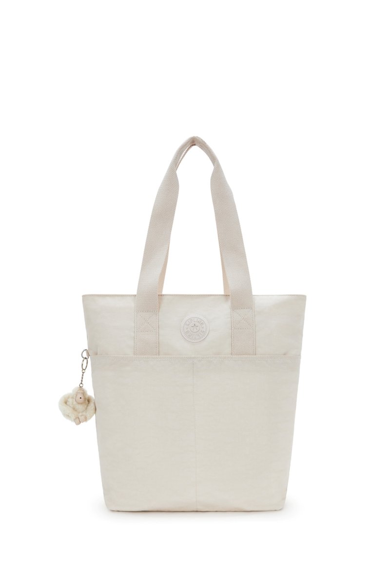 Beige draagtas van een gestructureerde stof, met twee stevige handvatten en een circulair logo. Bevat een klein pluche hangertje.