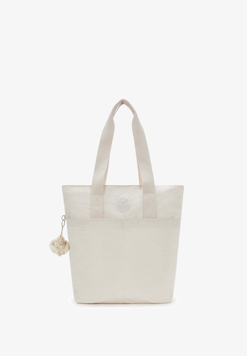 Beige draagtas van een gestructureerde stof, met twee stevige handvatten en een circulair logo. Bevat een klein pluche hangertje.