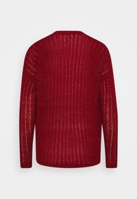 Czerwony sweter z dzianiny o luźnym, teksturowanym wzorze. Posiada długie rękawy i okrągły dekolt, przedstawiając ciepły i przewiewny design.