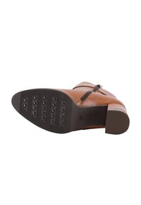 Braune Leder-Ankelstiefel mit seitlichem Reißverschluss, runder Spitze und strukturiertem Gummisohle mit erhöhten Punkten für besseren Halt.