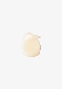 Creamy white cosmetic product in a smooth, glossy texture, shaped like a small dollop, with a slight sheen reflecting light.