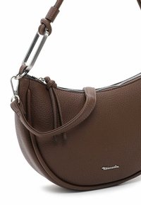 Sac à main en cuir marron avec une finition texturée, forme incurvée, matériel en argent, fermeture éclair et une bandoulière ajustable.