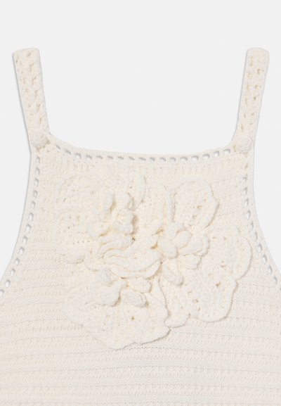 Crochet top in off-white with wide straps. Features a textured floral detail on the front and open stitching along the edges.