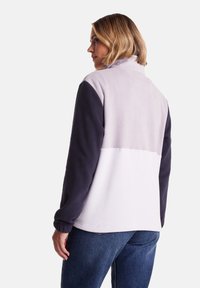 Fleece jacket in light gray and navy, featuring a high collar, long sleeves, and a smooth texture with color-blocked design.