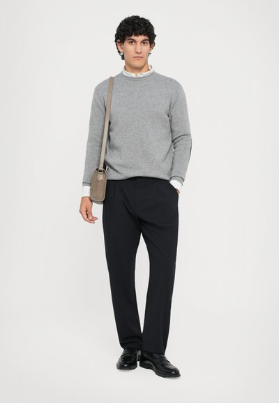 Hall suur hall soe, mustad püksid ja mustad kingad. Mudel hoiab väikest neutraalse värviga kotti. Cotton materjal, vabaaja lõige, ümmargune kaelus.
