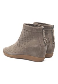 Bottines en daim marron avec un design perforé, semelles en caoutchouc flexibles et fermetures éclair à l'arrière. Texture lisse, bout arrondi.