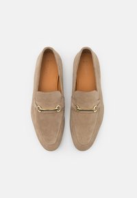 Beige semskede loafers med en gullfarget kjedeaccent, med sømdetaljer og design med rund tå. Jevn indre fôr og flat såle.