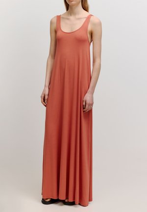 Robe maxi longue sans manches en tissu corail doux. Dotée d'un large col rond et d'un design fluide, atteignant les chevilles.